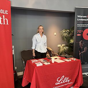 Ausstellerstand Lilly auf den Interdisziplinären Adipositas Tagen 2026 in München mit Vertreterin und zwei Teilnehmerinnen.