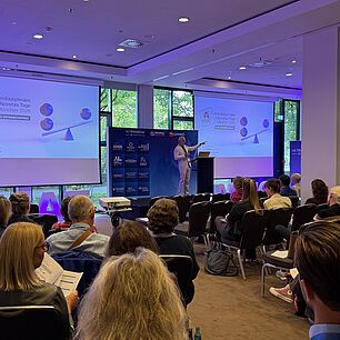 Eröffnung der Interdisziplinären Adipositas Tage 2026. Herr Prof. Dr. Horbach auf der Bühne. Gefüllter Konferenzraum im Vordergrund.